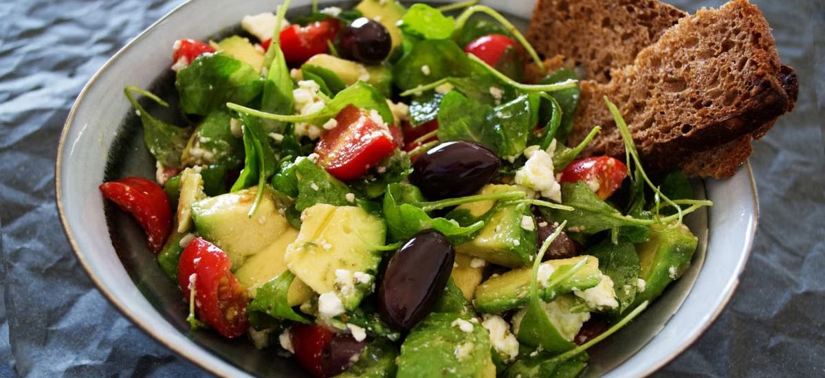 Delicious Greek salad featuring avocado, feta, and olives, ideal for a healthy meal.