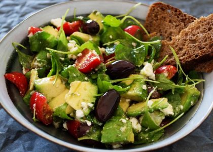 Delicious Greek salad featuring avocado, feta, and olives, ideal for a healthy meal.