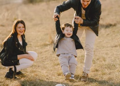 Family enjoying playful soccer game outdoors, capturing joyful moments.